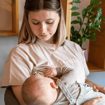 Frau am stillen im rosa-beige creätr T-Shirt mit Reisverschluss 