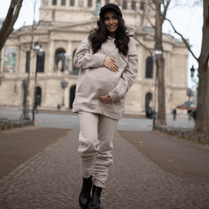 Schwangere Frau im rosa-beige creätr Outfit - Hoodie, Jogger