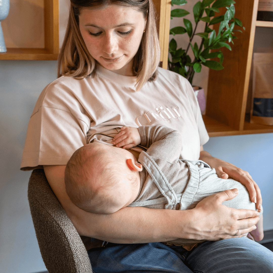 Frau in creätr T-Shirt und Jeans am stillen